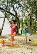 底地ビーチの木陰で、片足立ちでヨガをする二人の女性